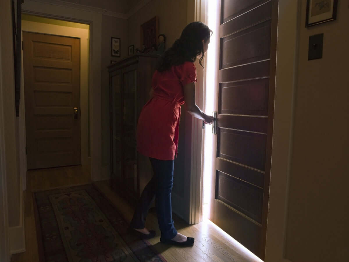 young happy woman peeking through door