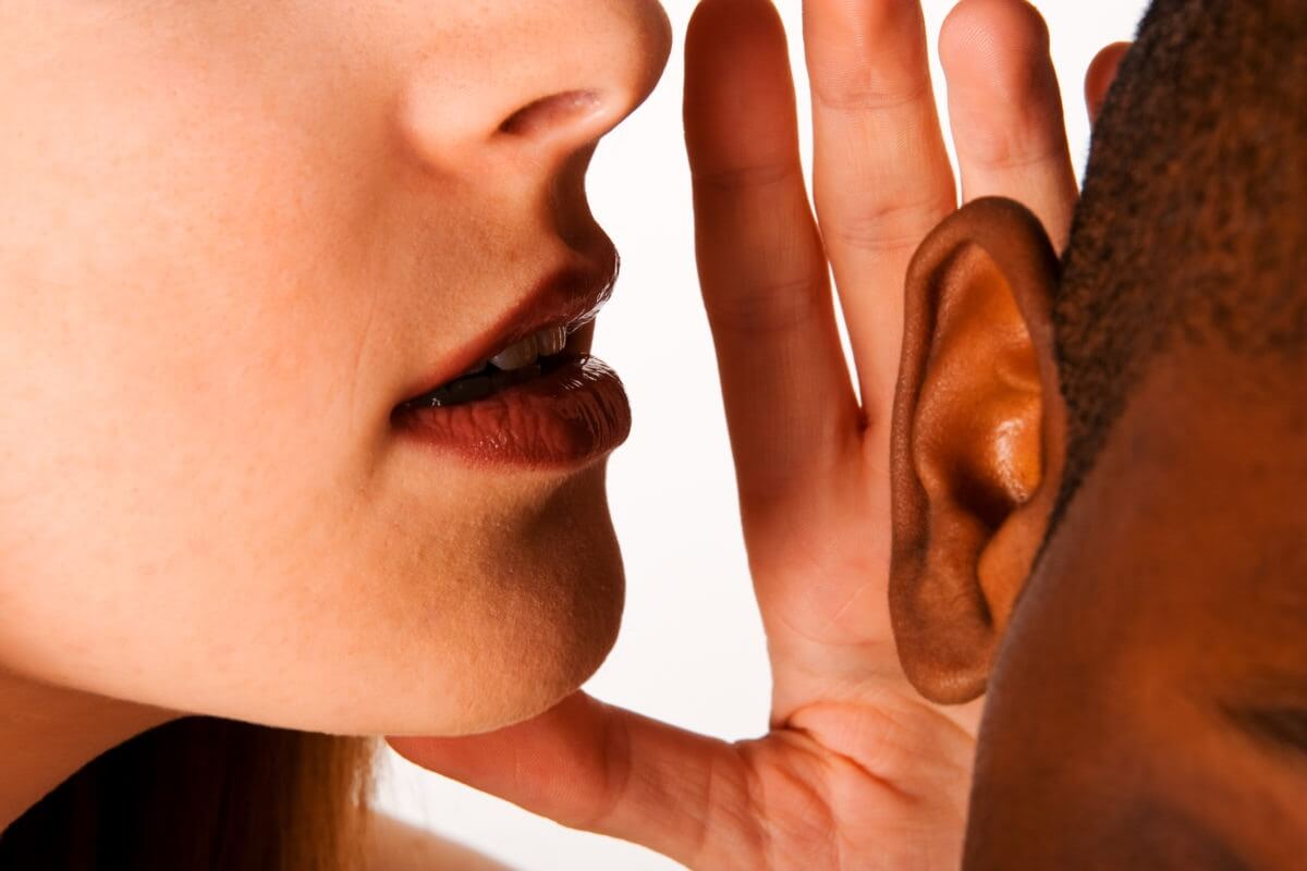 lady whispering to little boy's ear