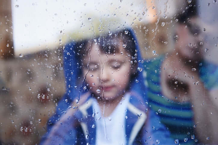 rainy weather little boy behind the glass