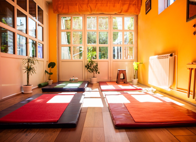 different color yoga mats in a yoga studio with light coming in