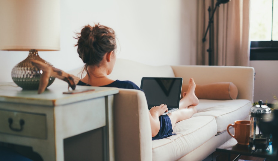 woman sitting on a couch looking at her computer