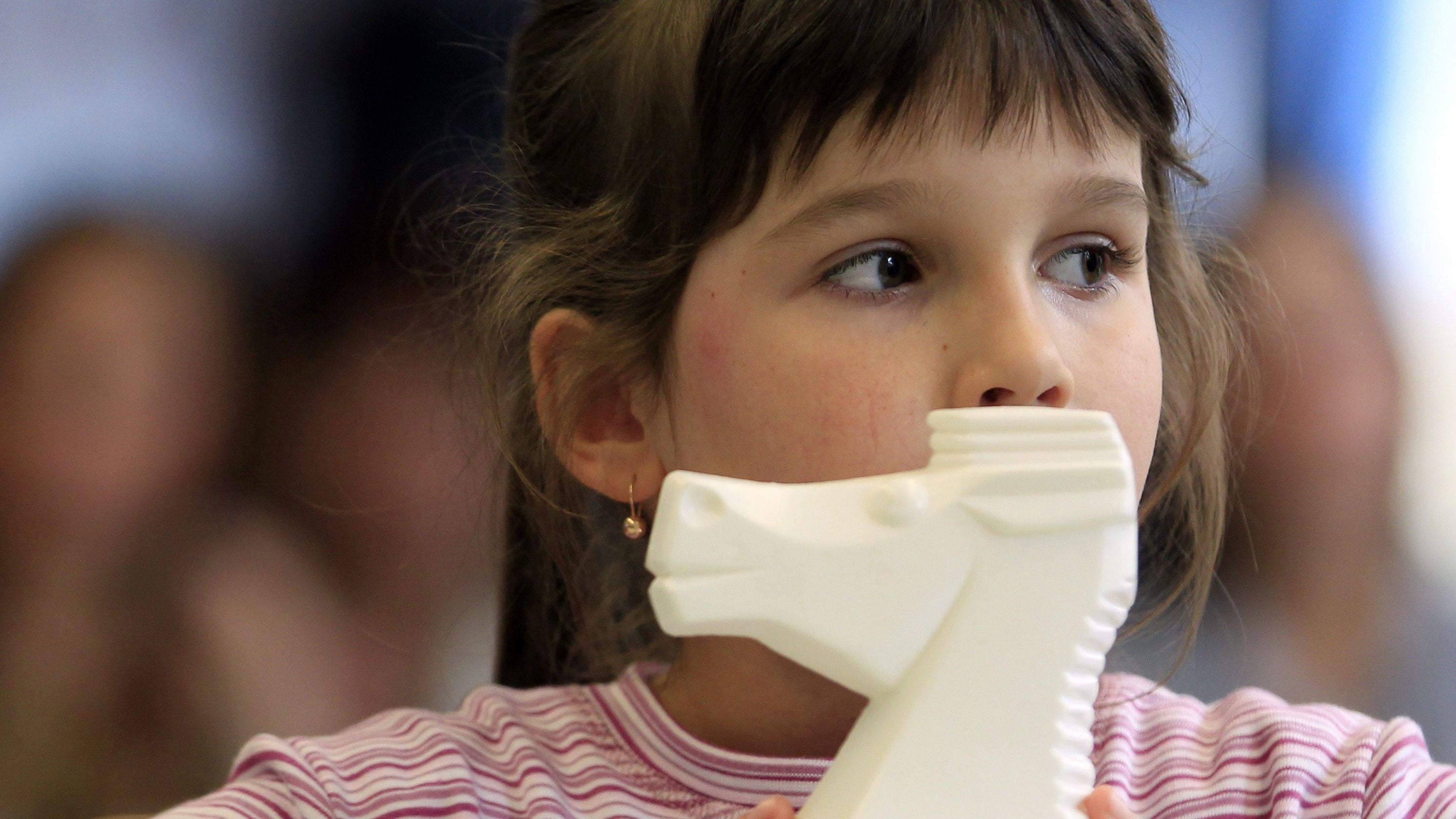 young girl holding her toy horse