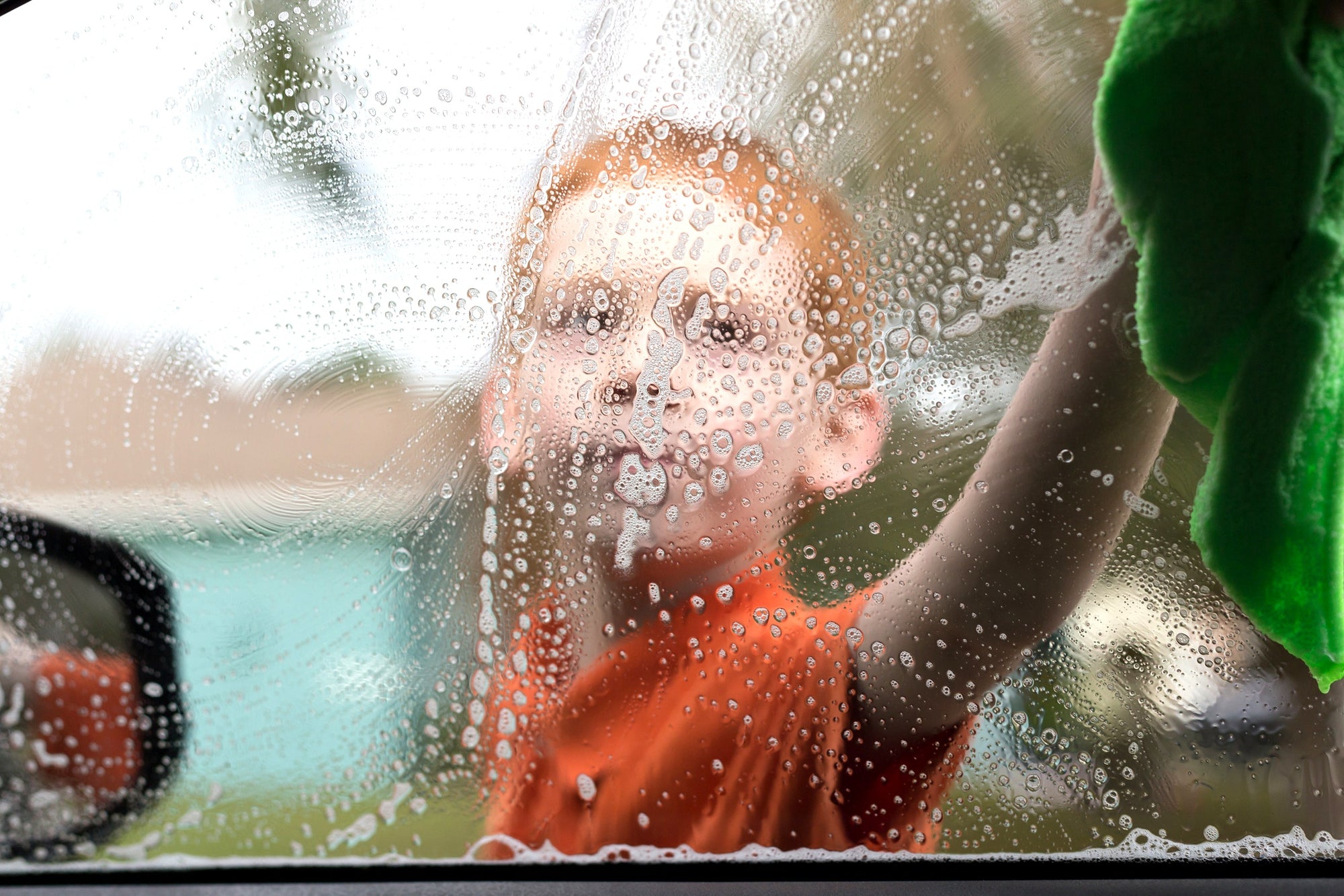 A child washing a car's window
