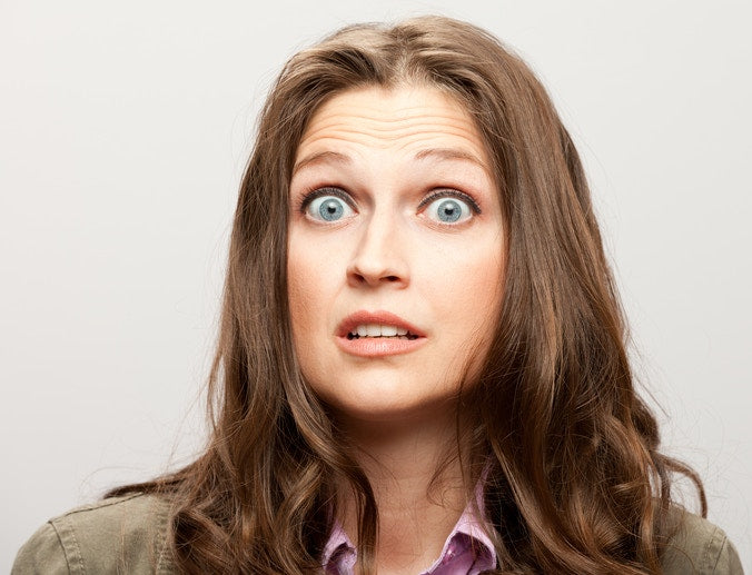 Young woman with blue eyes standing with disgusted expression, displeased and fearful doing disgust face