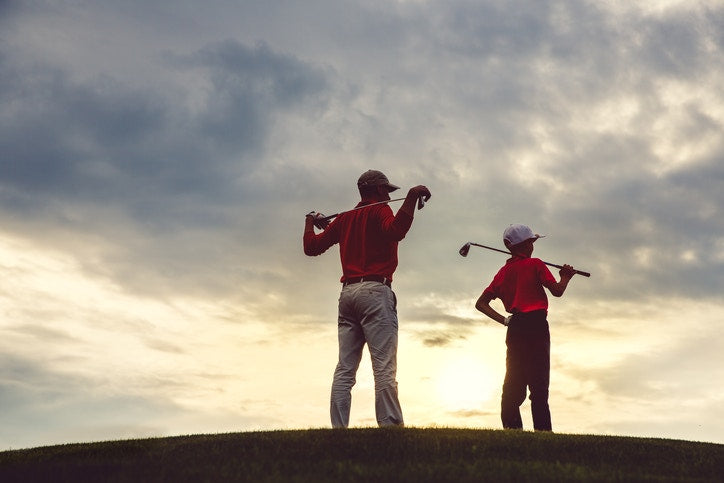 A father and his child playing golf and watching  the sky