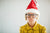 child with christmas hat and spectacles holding breath