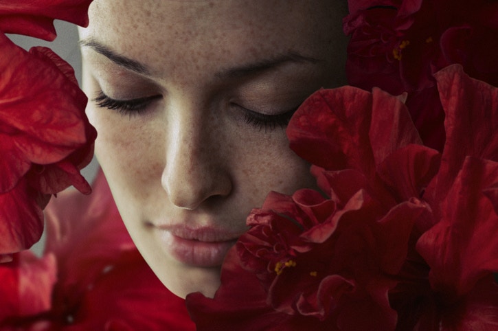girl face surrounded by red flowers