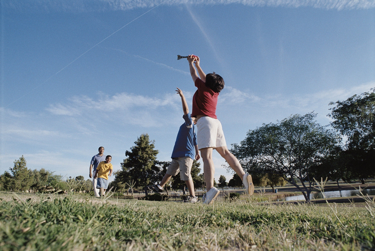 father playing with three sons at the field