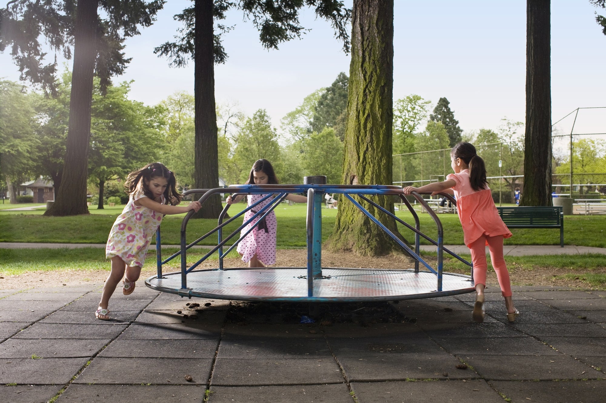 young girls playing on roundabout 