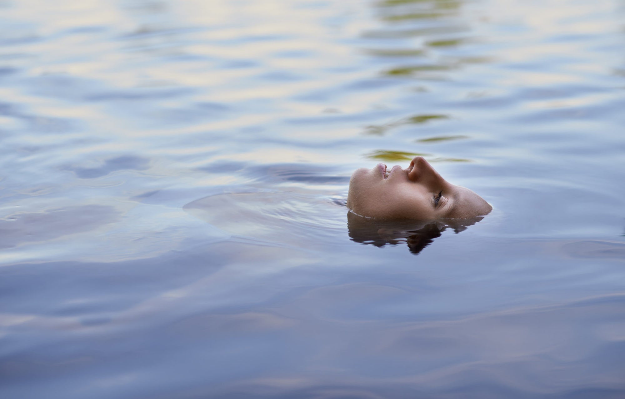 women float in lake with face-up