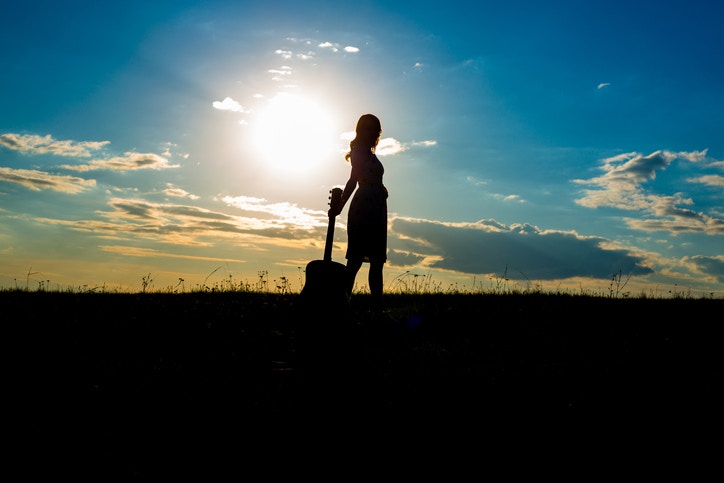 women standing with guitar