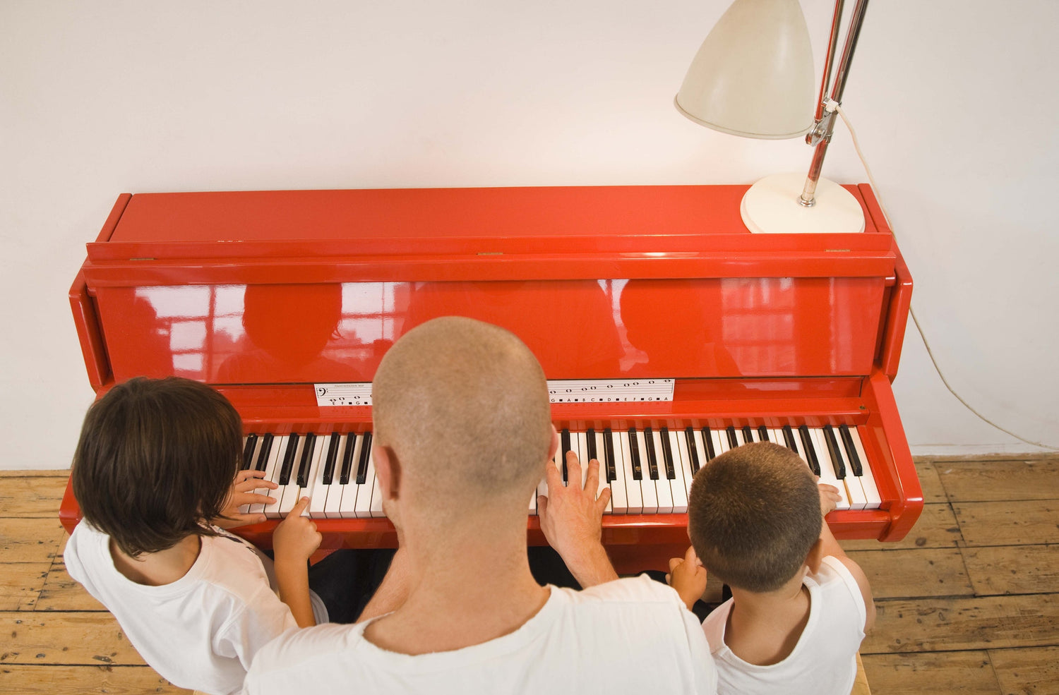 Father teaching son how to play the piano