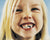 young girl with blonde hair showing teeth