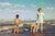 two boys with young mother playing on the beach