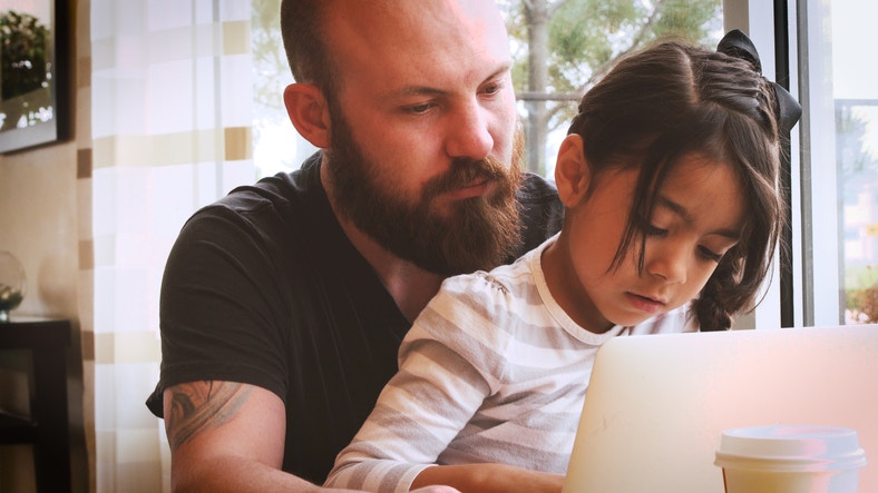 young father have fun with his little daughter during working with laptop