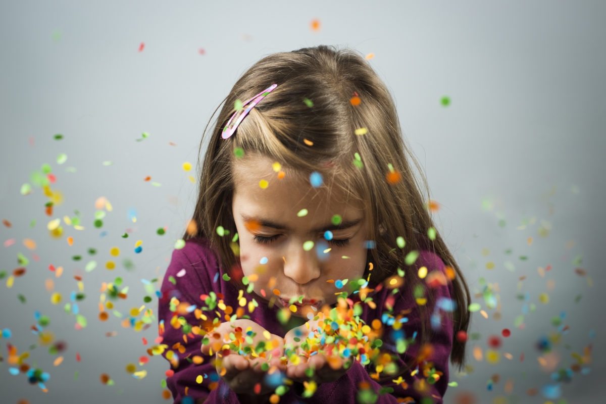Child blowing confetti