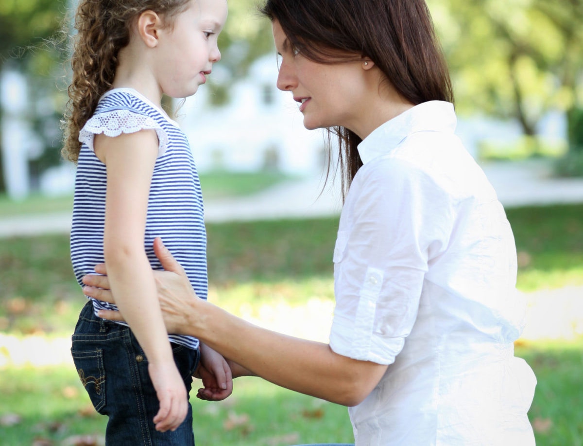 Concerned mom and daughter talk at park
