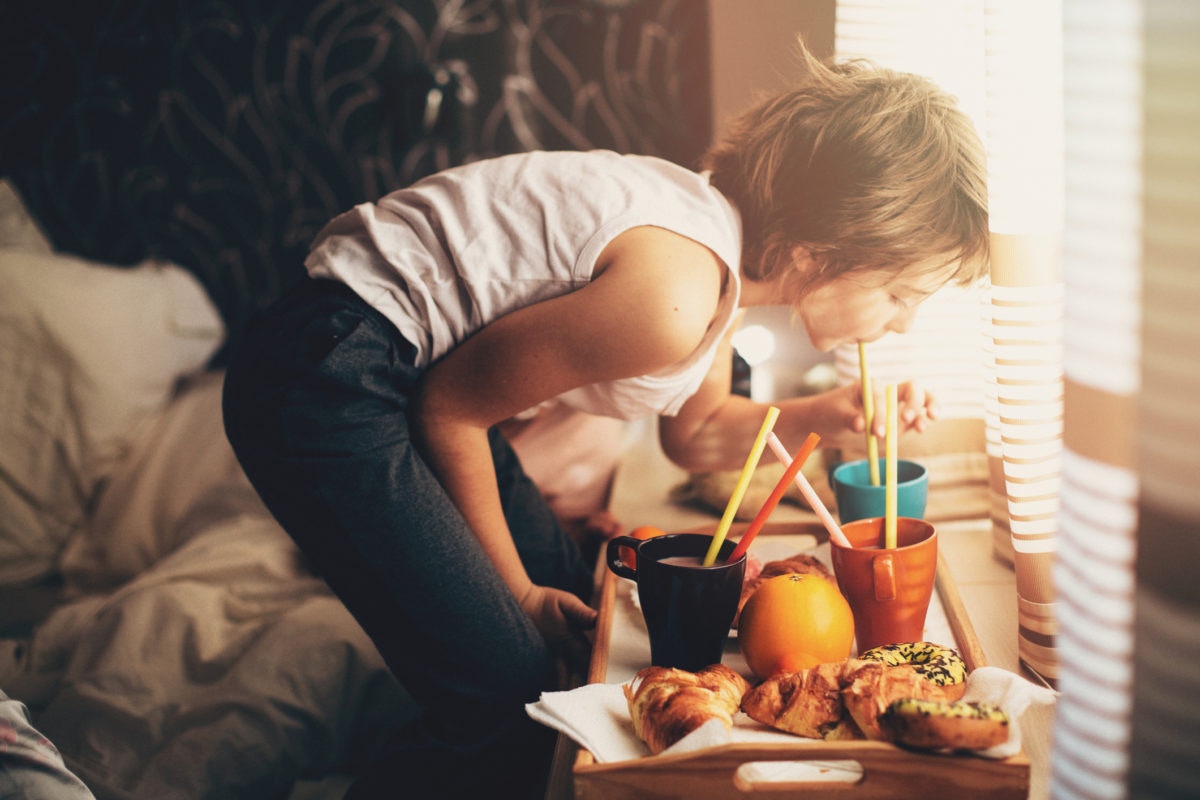 A child drinking from a glass using a straw