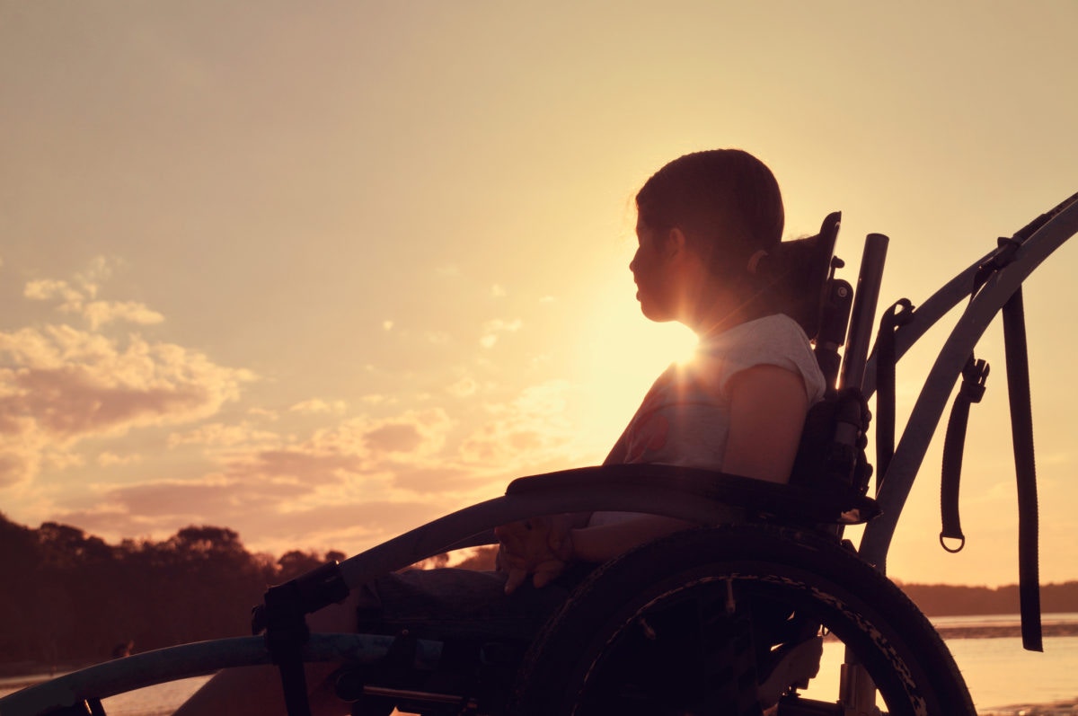 young girl in a wheelchair enjoying a sunset view