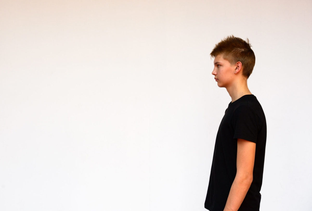 side view of a boy standing over white background