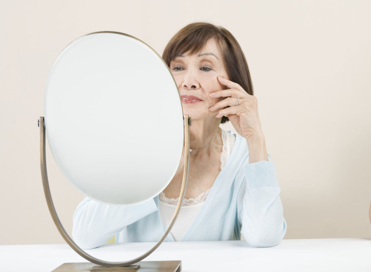 happy elderly woman looking at mirror