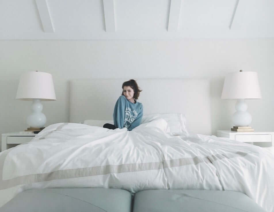 Girl posing while sitting on bed in the morning