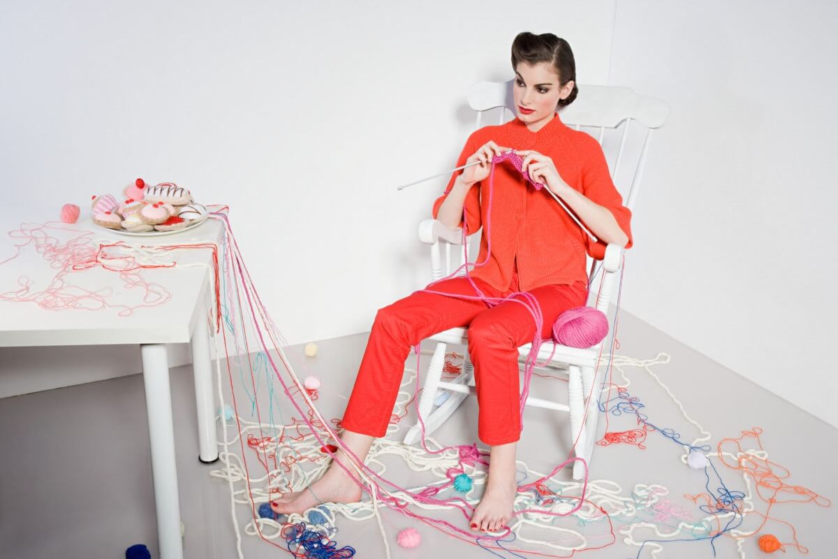 Young Woman Knitting At Home