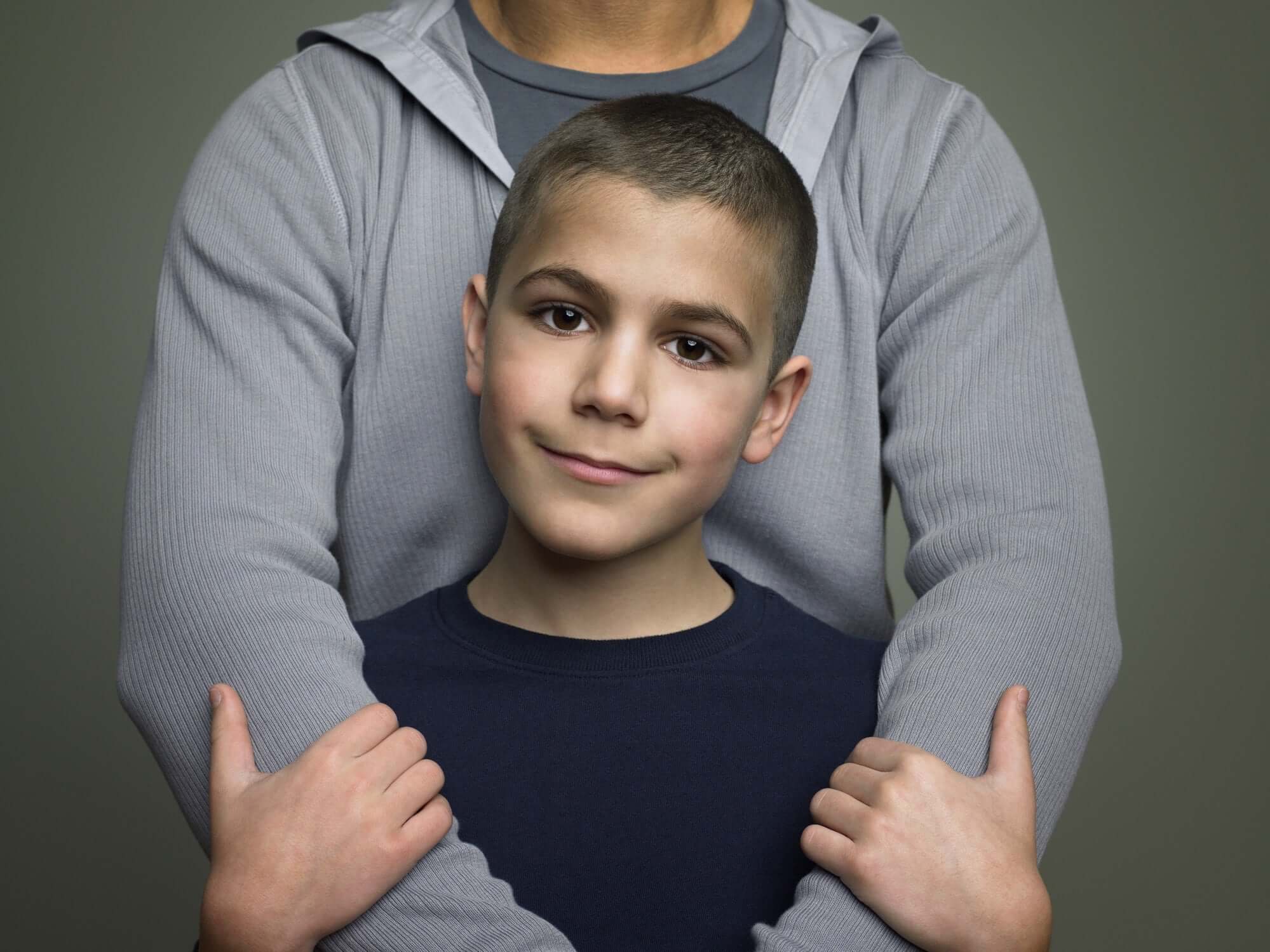 A father hugging a child from back