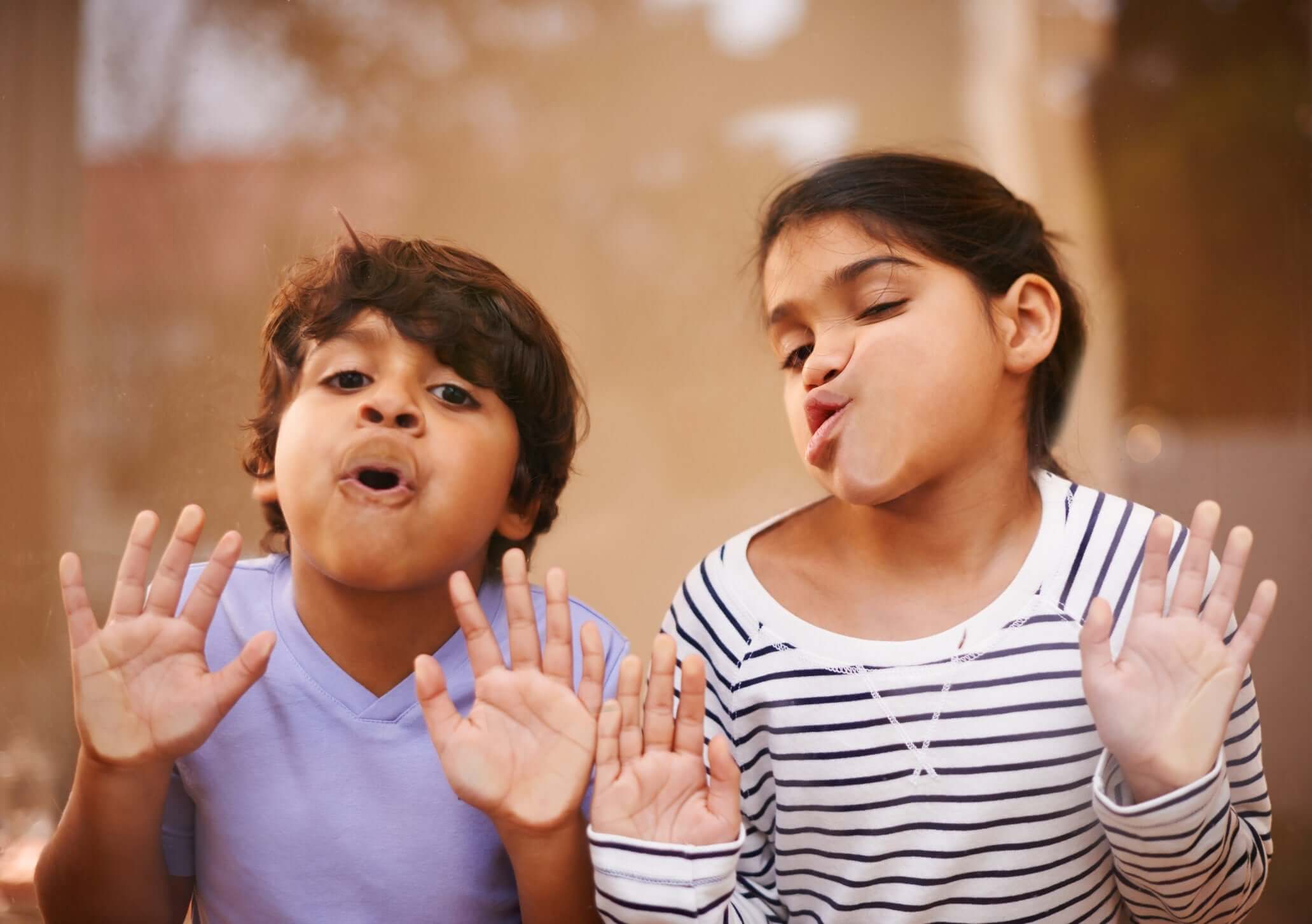 young girl and boy close up on face reflecting in a mirror
