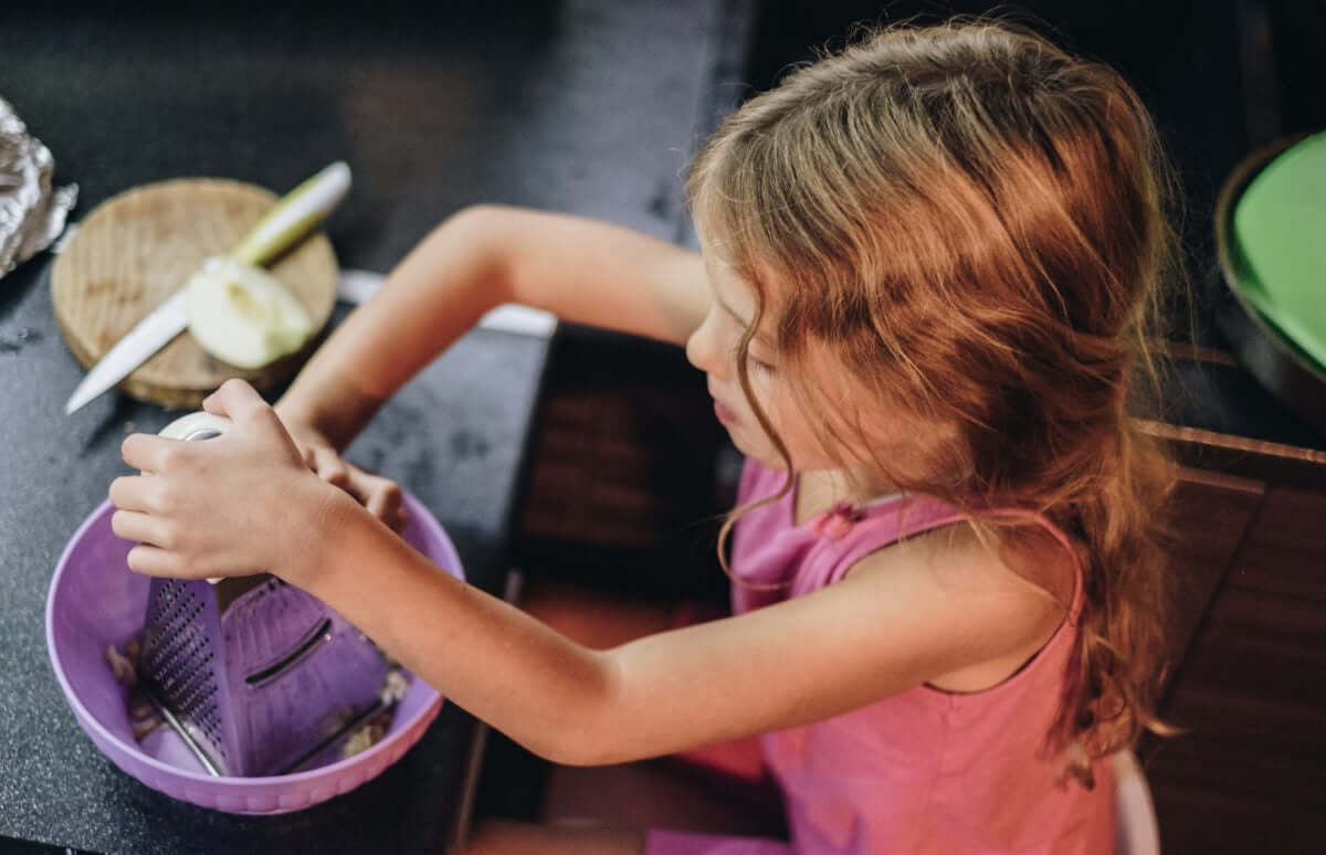 little girl grating cheese