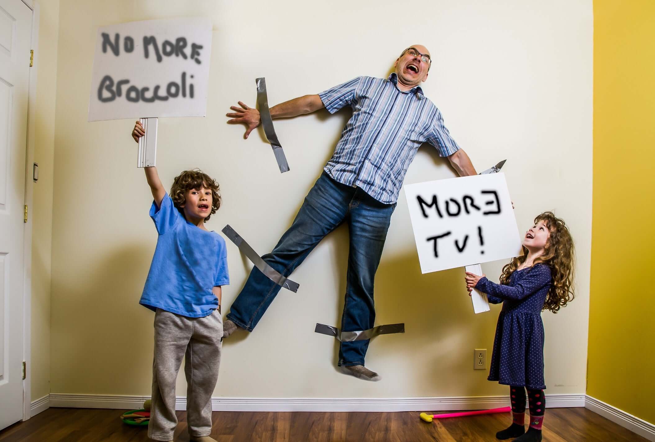 children standing with boards father sticked on the wall behind them