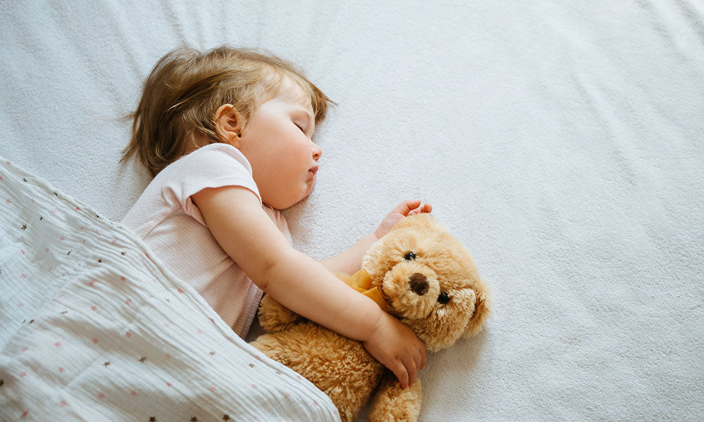 baby sleeping with teddy bear
