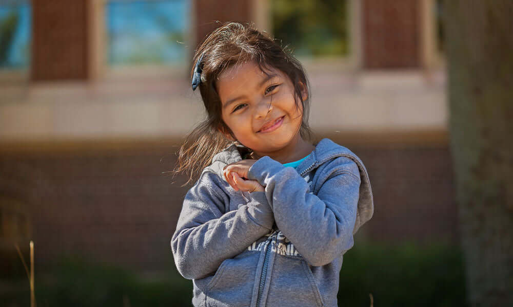 girl holding her hands together who is expressing love