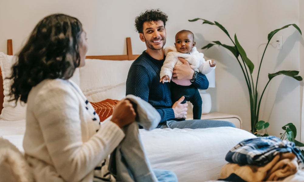 dad and mom in bed with baby
