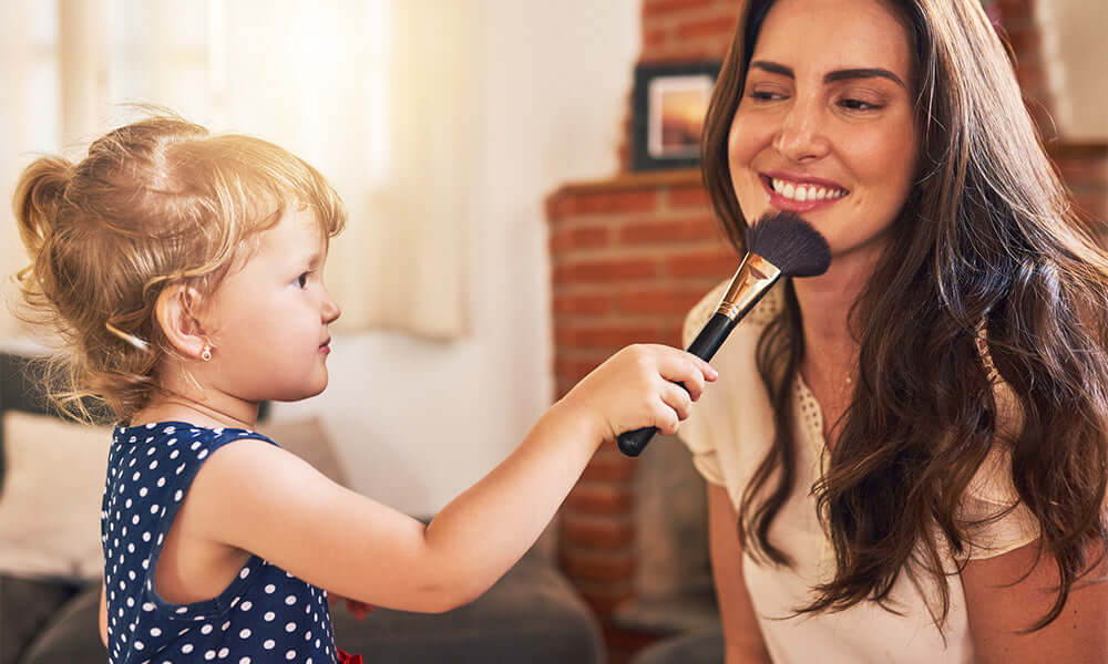 child putting makeup on mom