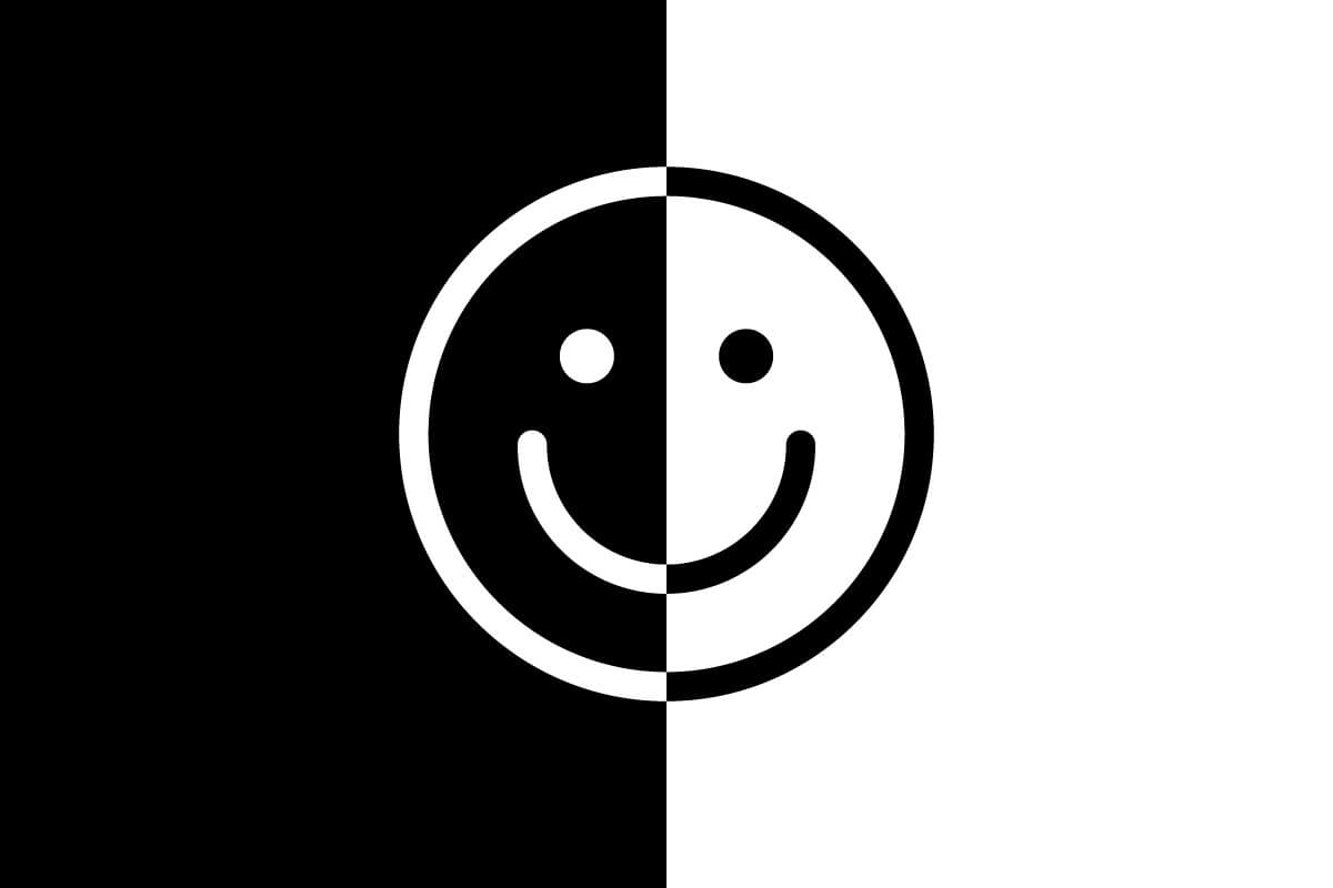 happy face emoji in half black and half white