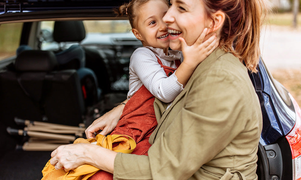 mother and daughter in back of car