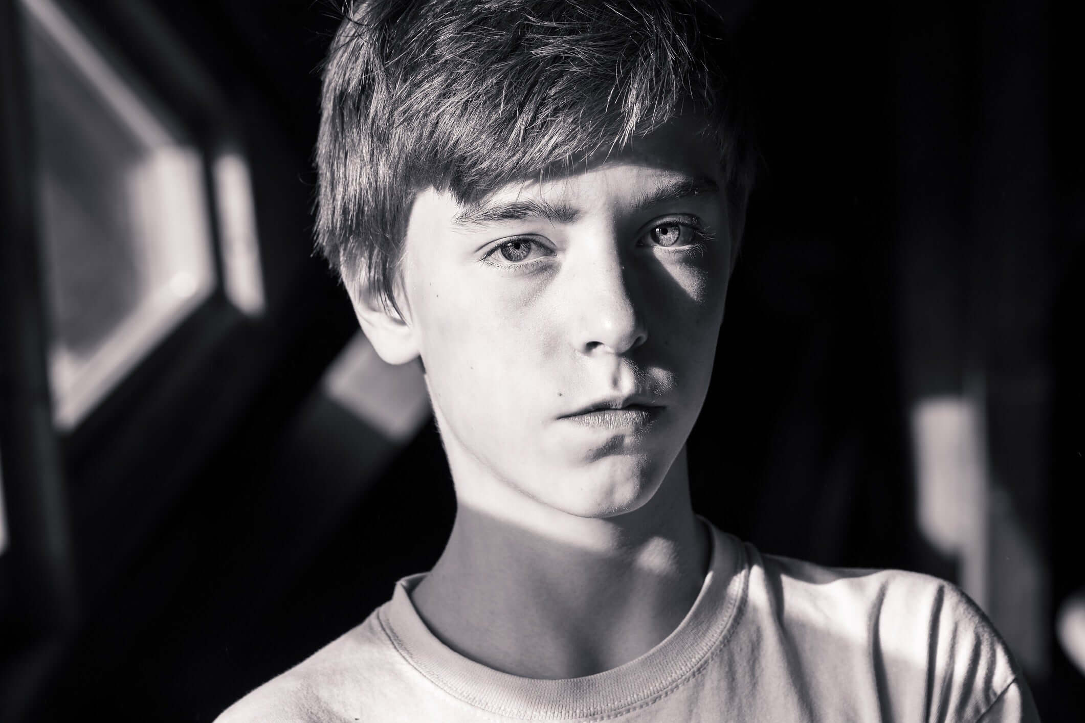 a boy looking at the camera  in the park in sun rays