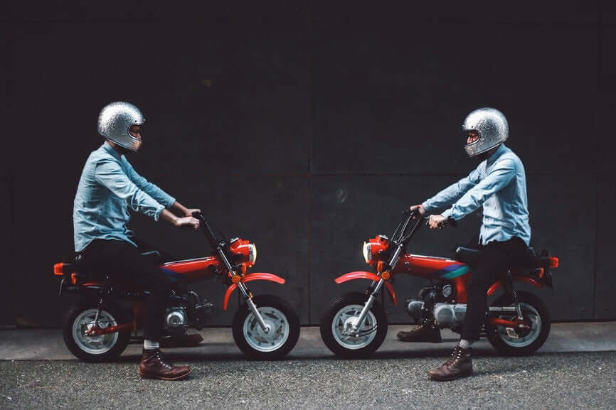 two men sitting in bikes facing opposite to each other