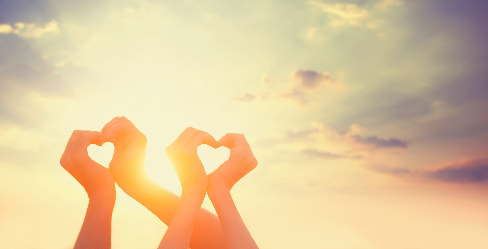 two people making heart symbol with their hands