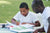 Young boy doing his school homework with his father.