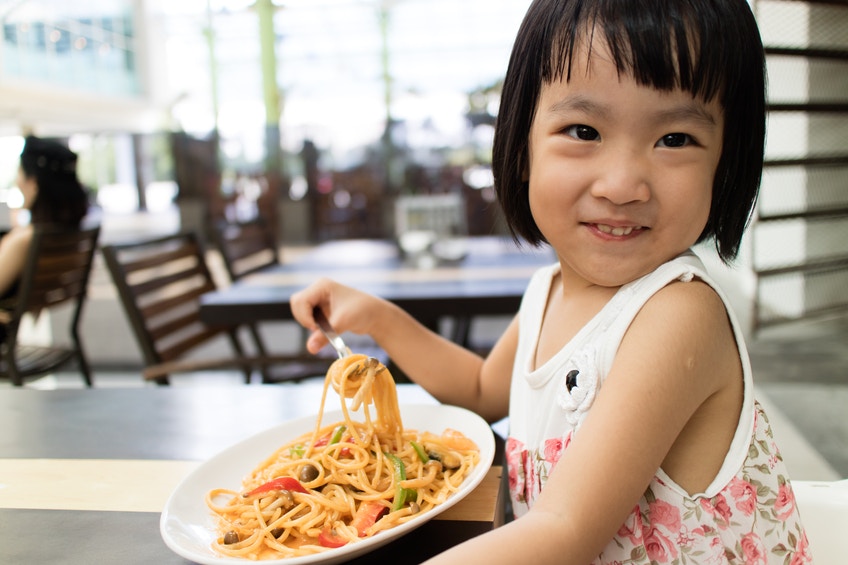 little girl eating spagetti