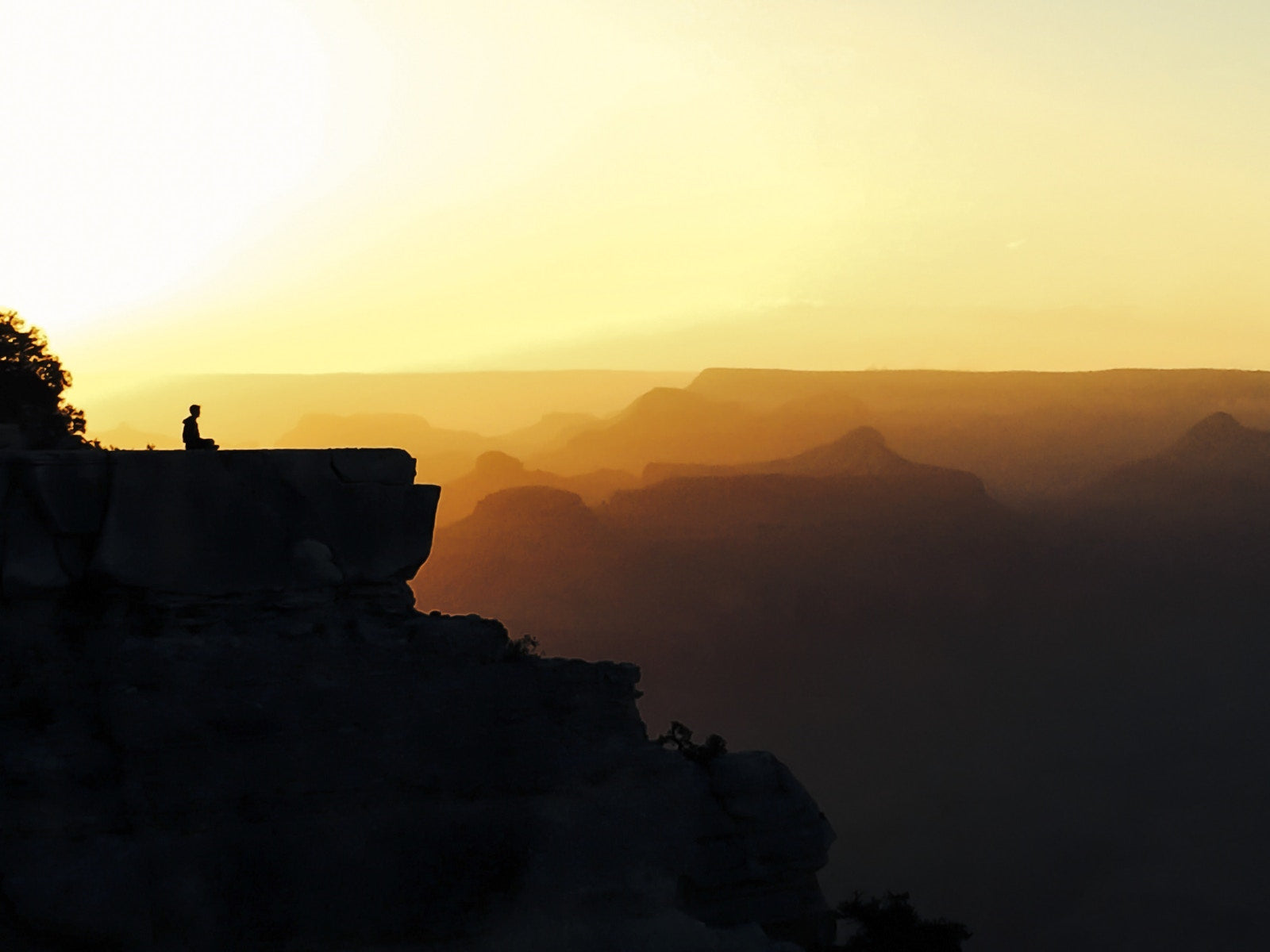 man sitting alone on mountain background is sunset