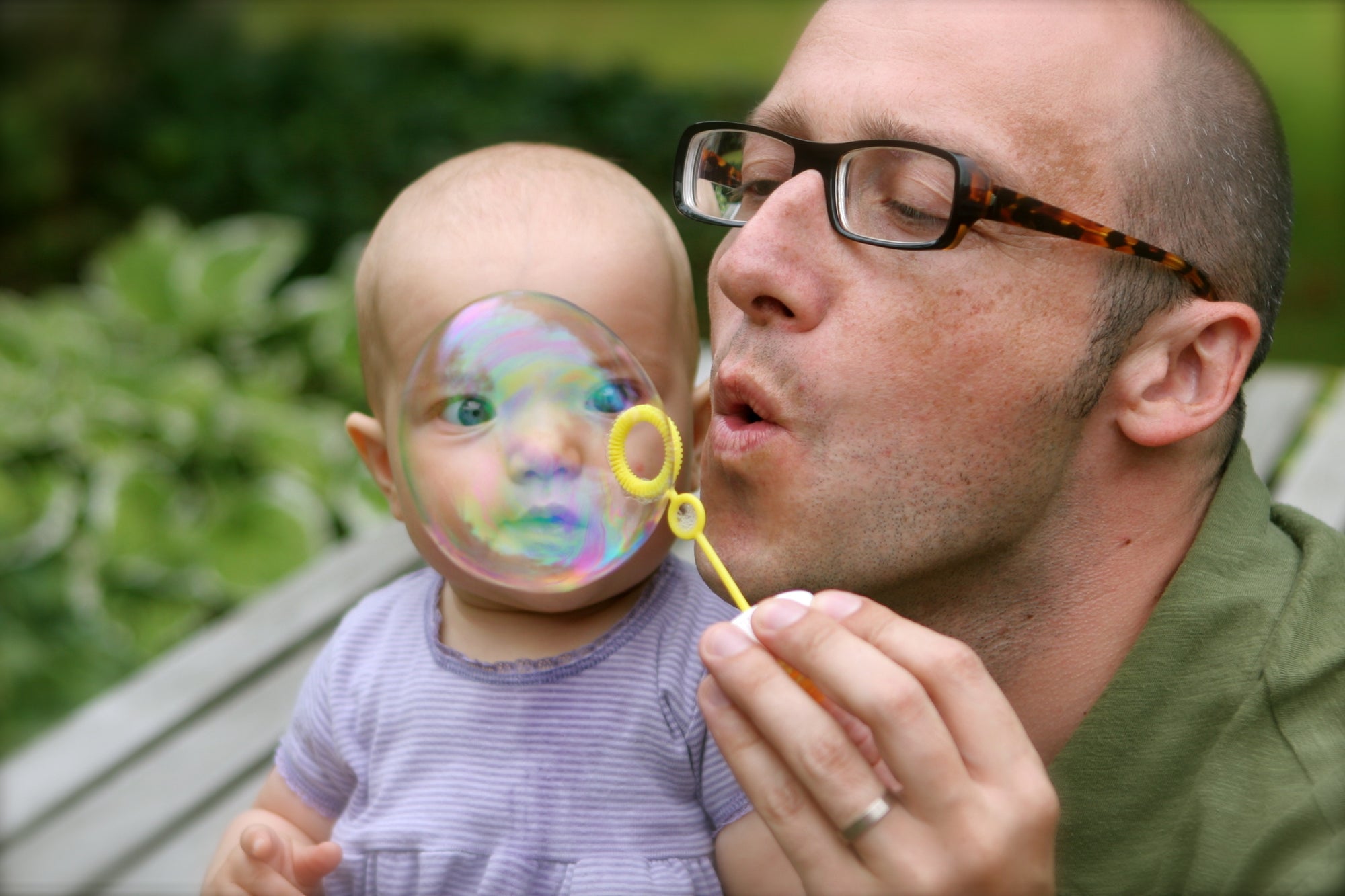 A father playing with his child, showing bubbles
