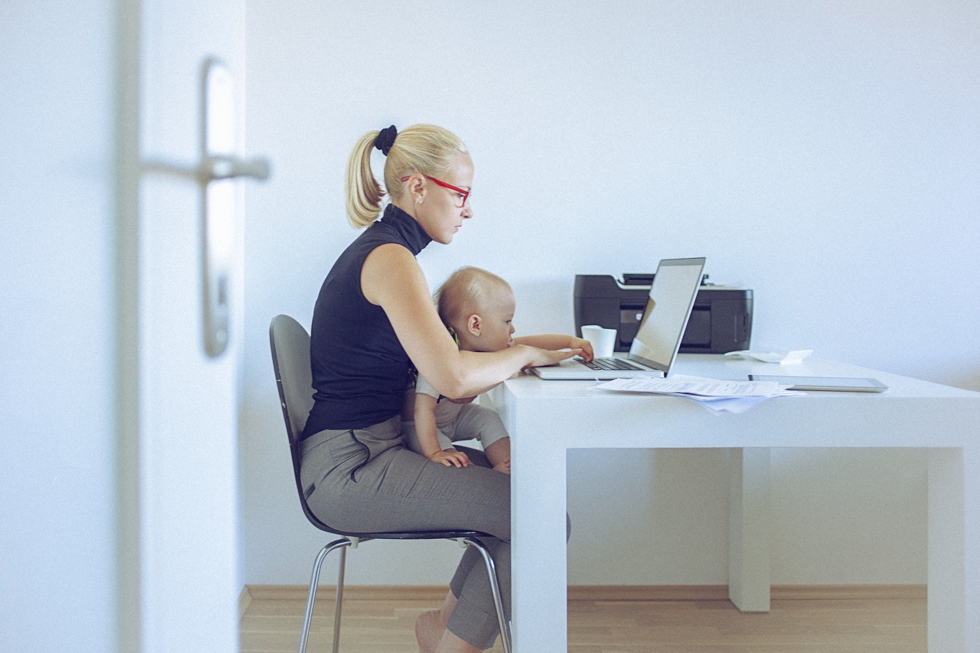 Women working on laptop with toddler on her lap