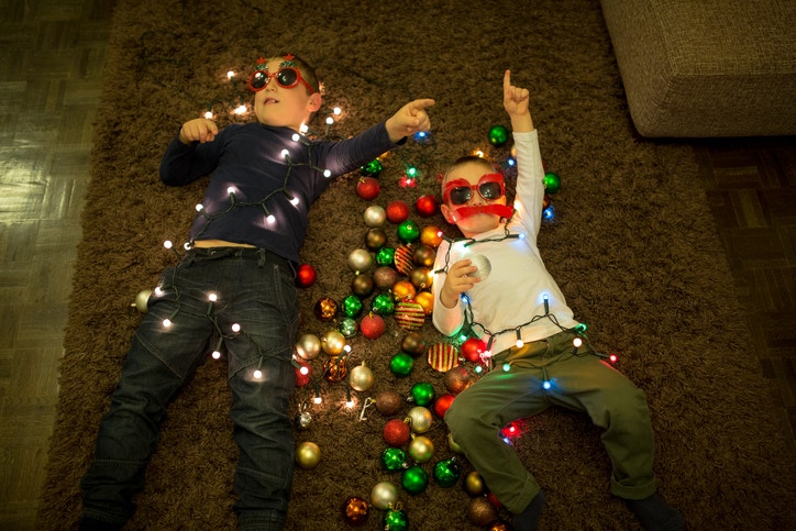 Two children lying down with christman bulbs