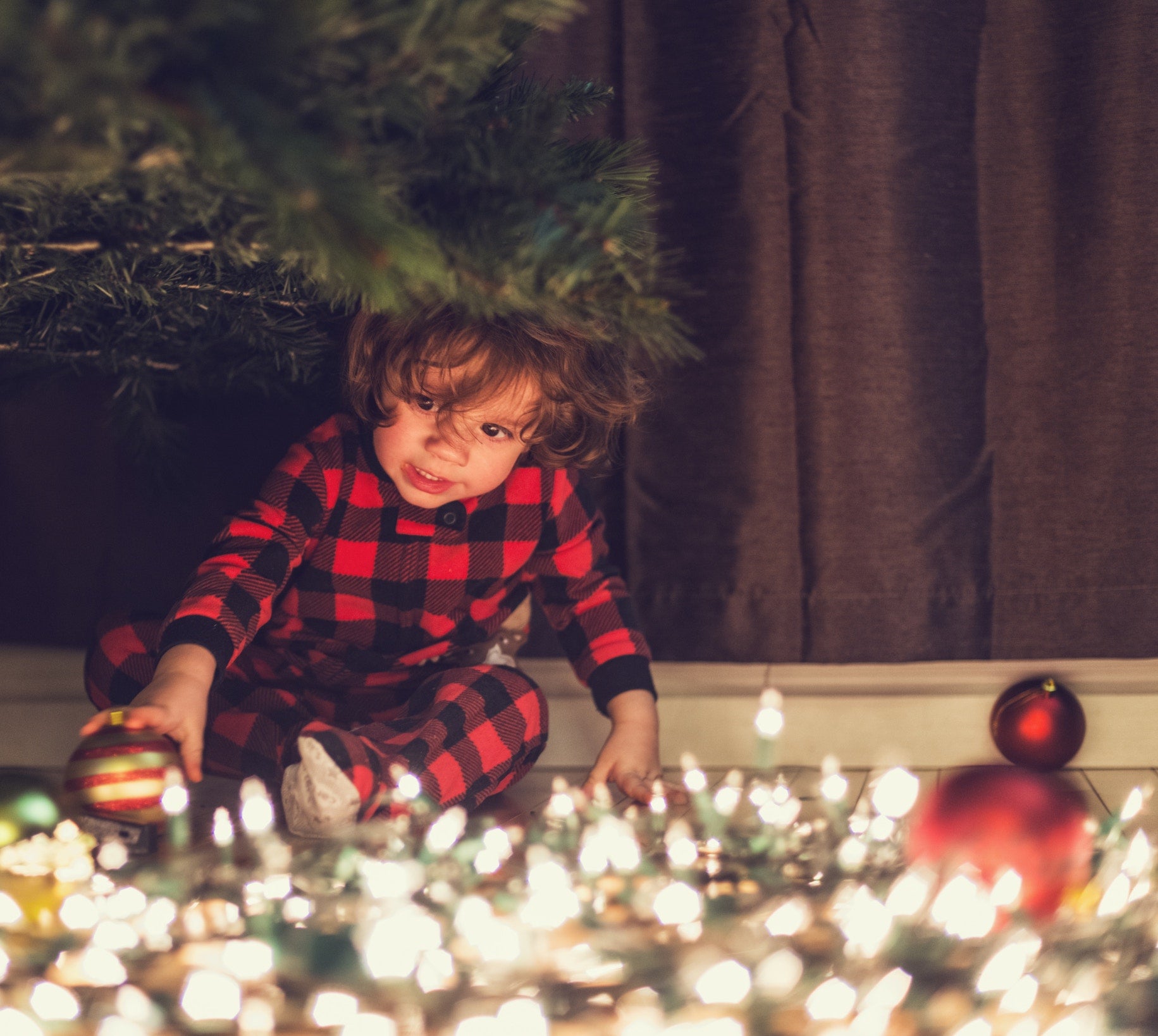 A child playing with christmas lights