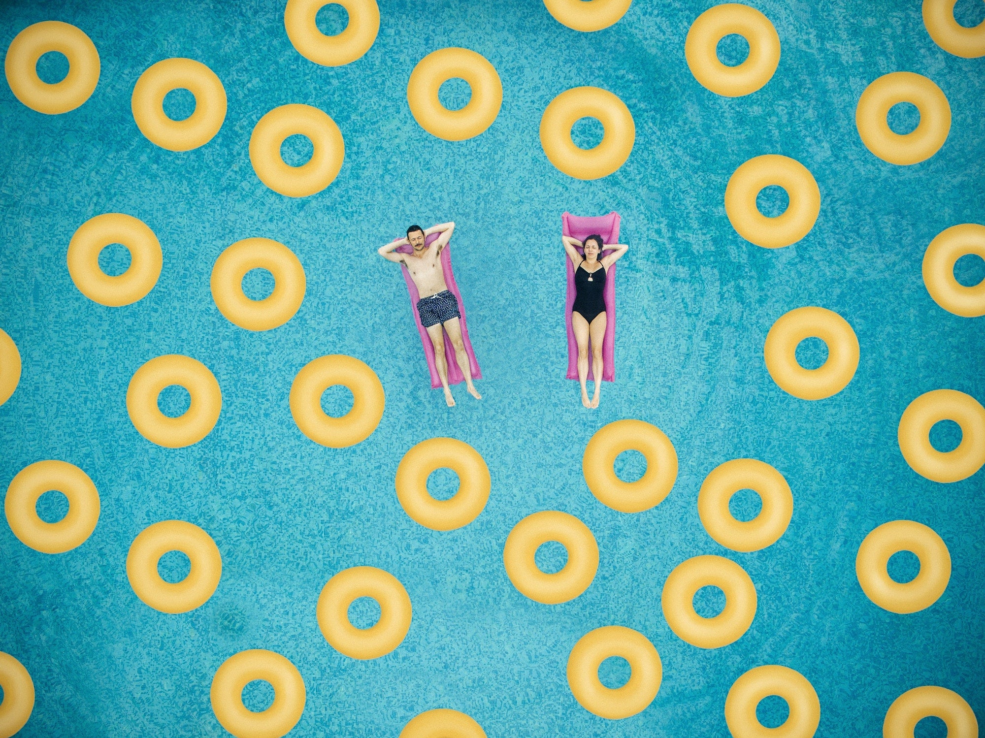 A couple in a pool full of swimming rings