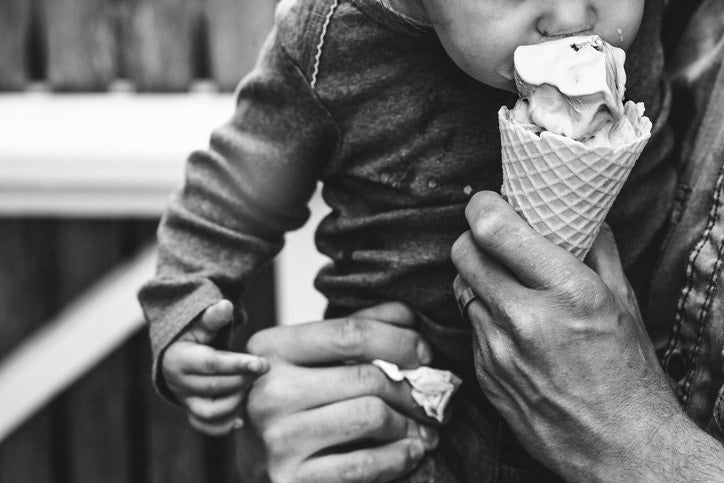 Baby smiling and drooling when trying for the first time an ice cream from his mother`s hands
