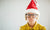 child with christmas hat and spectacles holding breath